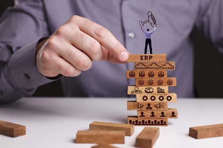 man stacking blocks to show competitive advantage of erp